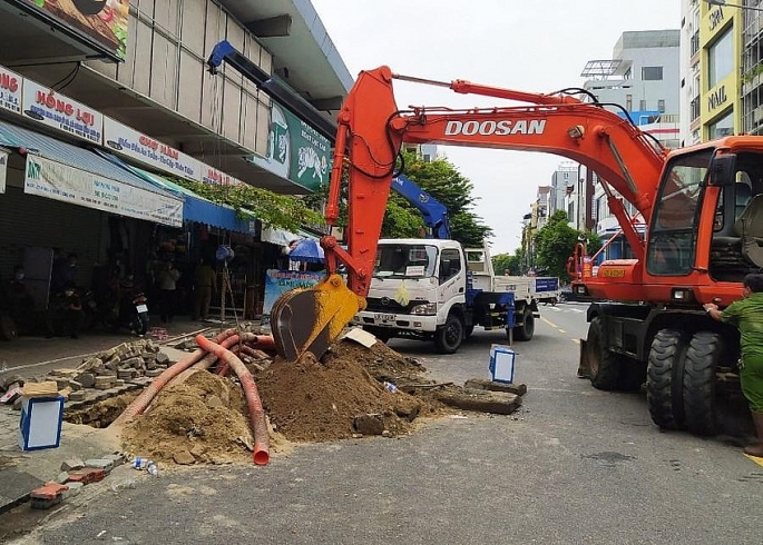 Lực lượng chức năng huy động nhiều máy móc để đào đường cống, đưa thi thể lên.