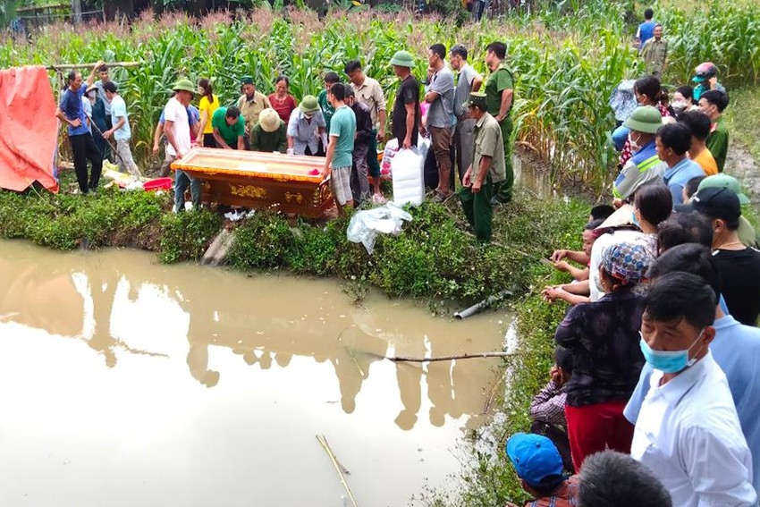 Gia đình làm thủ tục mai táng ngay tại nơi hai cháu bé bị đuối nước. Ảnh: ĐT